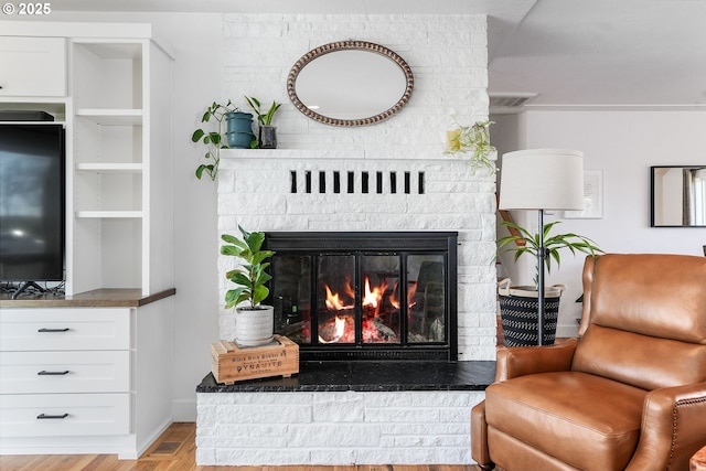 living room with wood finished floors and a glass covered fireplace