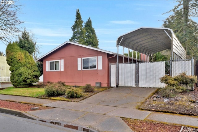 view of side of property with a gate, a detached carport, and fence