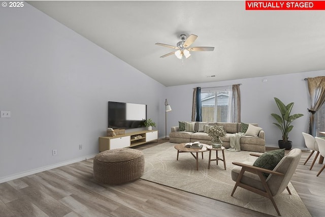 living area with visible vents, baseboards, ceiling fan, vaulted ceiling, and light wood-style floors