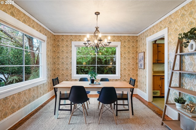dining space featuring baseboards, a notable chandelier, and wallpapered walls
