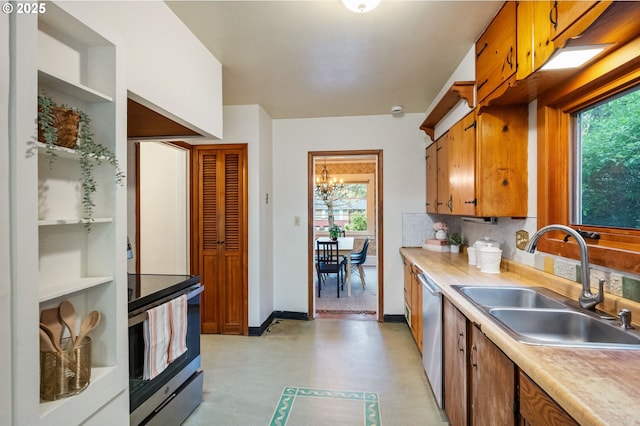 kitchen featuring a sink, appliances with stainless steel finishes, brown cabinets, and light countertops
