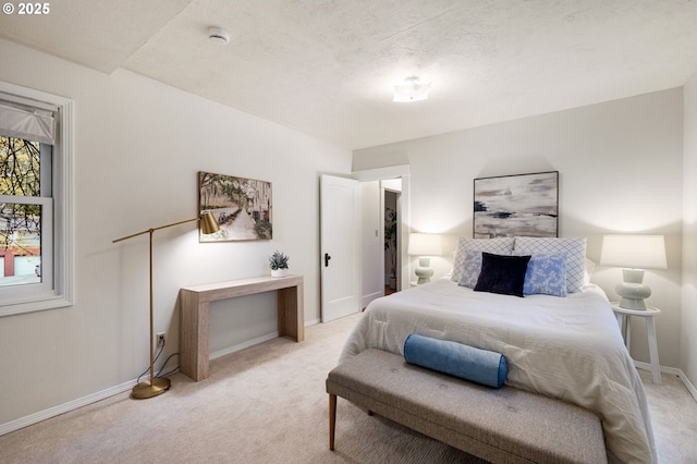bedroom with baseboards and light colored carpet