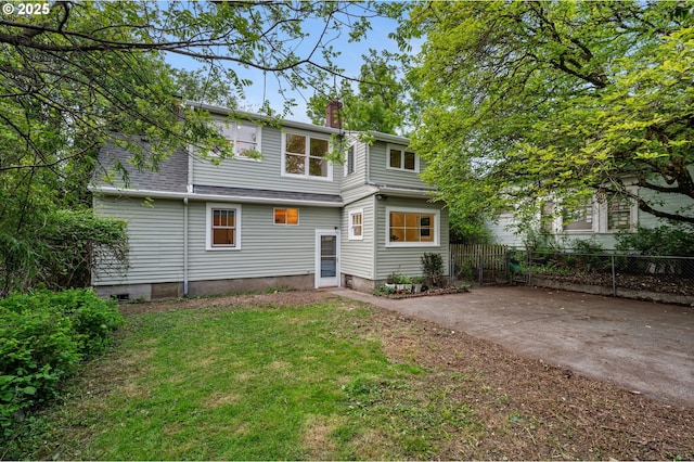 view of front of home with fence, a chimney, and a front lawn