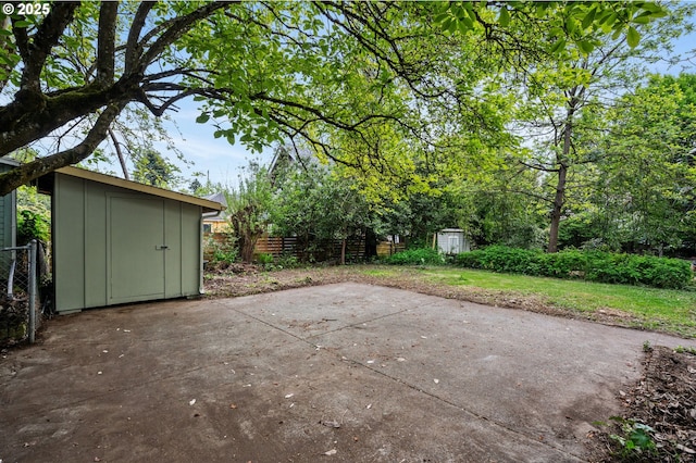 view of patio / terrace with fence, an outbuilding, and a storage unit