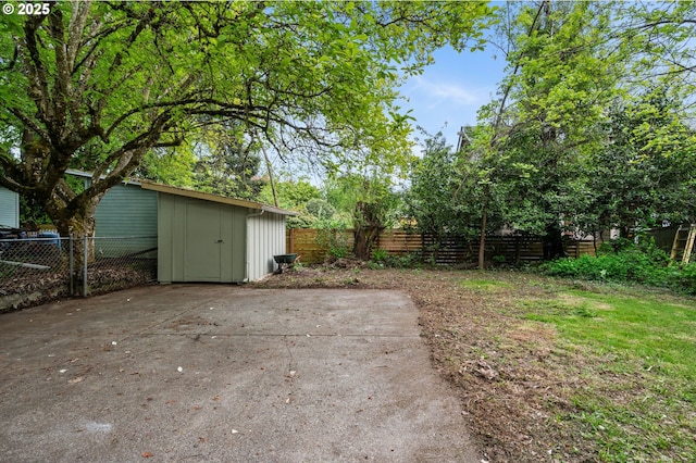 view of yard featuring an outbuilding, a fenced backyard, a patio area, and a storage unit