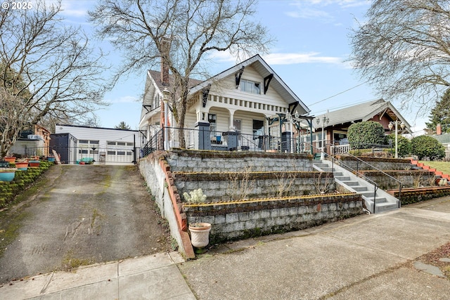 bungalow featuring stairs, driveway, and a porch