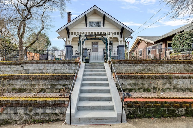 exterior space featuring covered porch, stairs, and a chimney