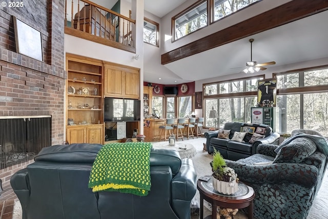 living room with a brick fireplace, a towering ceiling, and ceiling fan