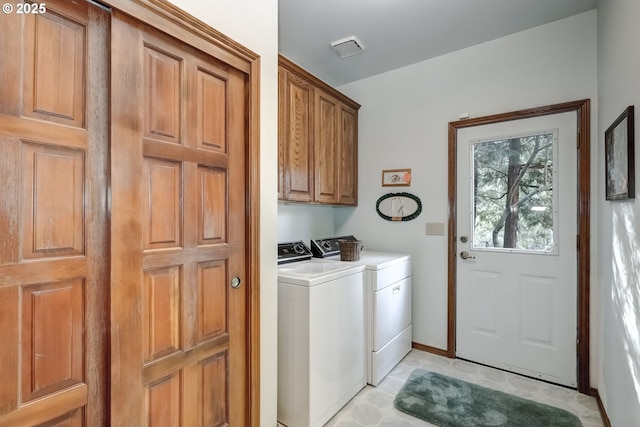 laundry room with cabinets and washing machine and clothes dryer