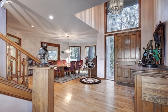 foyer entrance with an inviting chandelier and light hardwood / wood-style floors