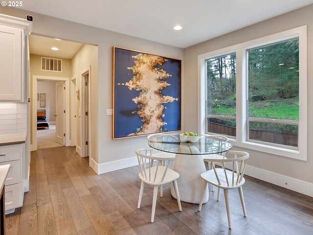 dining area with light wood-style floors, baseboards, visible vents, and recessed lighting