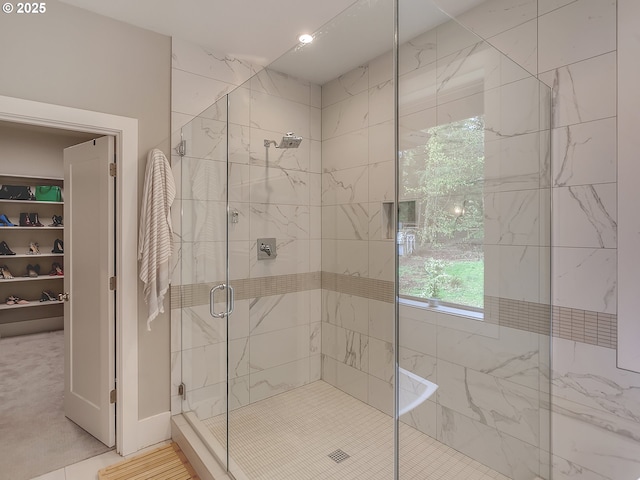 bathroom with a walk in closet and a stall shower
