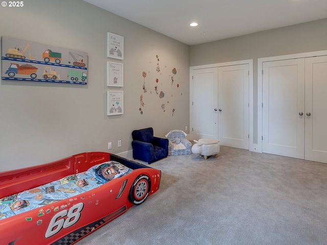 carpeted bedroom with recessed lighting and two closets