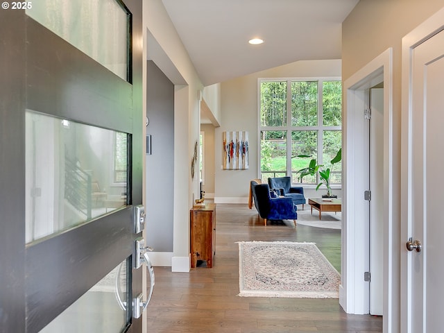 entryway featuring baseboards, recessed lighting, wood finished floors, and lofted ceiling