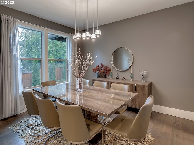 dining space with dark wood-style flooring and baseboards