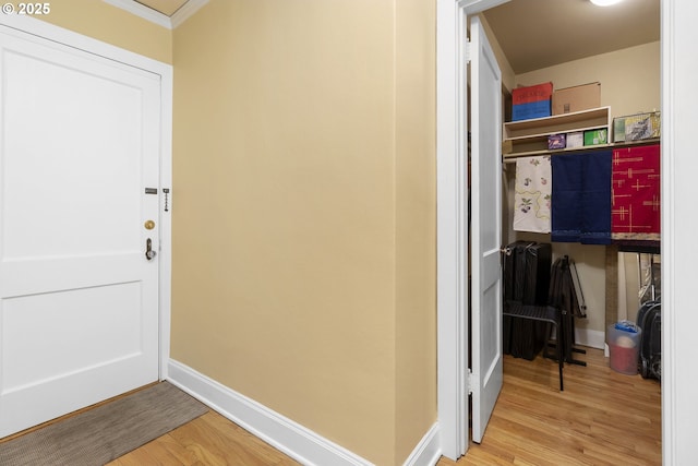 interior space featuring crown molding, baseboards, and wood finished floors
