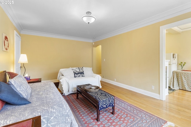bedroom featuring arched walkways, wood finished floors, baseboards, and ornamental molding