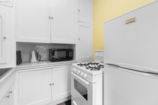kitchen with tasteful backsplash, light countertops, white appliances, and white cabinets