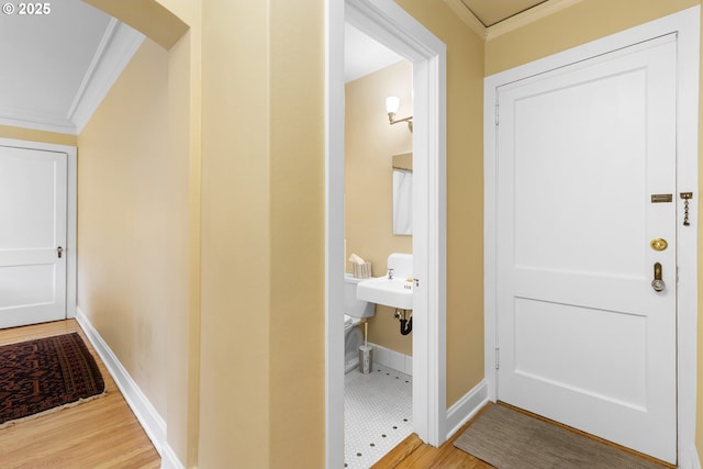 interior space with ornamental molding, baseboards, arched walkways, and wood finished floors