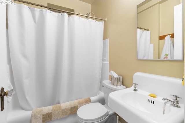 bathroom featuring a sink, toilet, and shower / bathtub combination with curtain