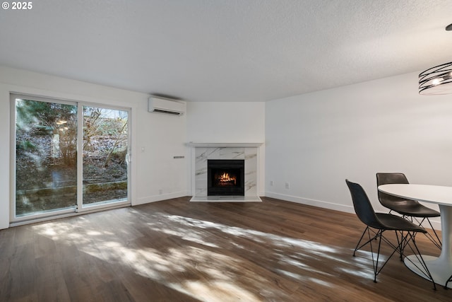 living room with baseboards, a wall mounted AC, and wood finished floors