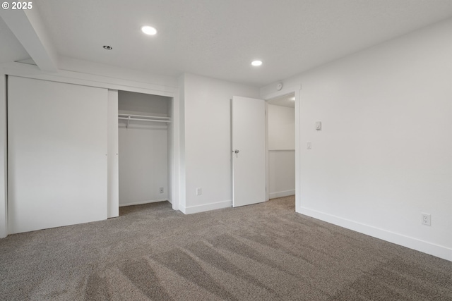 unfurnished bedroom featuring carpet, a closet, and recessed lighting