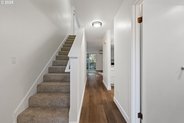 stairway featuring wood finished floors and baseboards