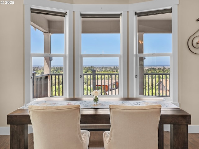 unfurnished dining area with baseboards, breakfast area, and wood finished floors