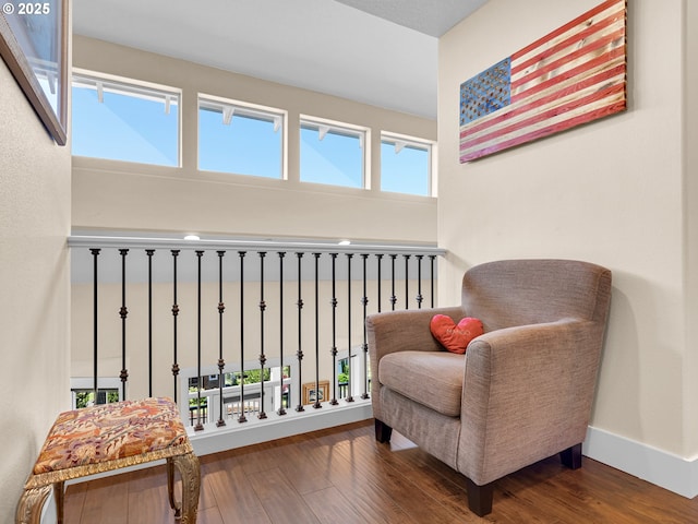 sitting room with baseboards, wood finished floors, and a healthy amount of sunlight