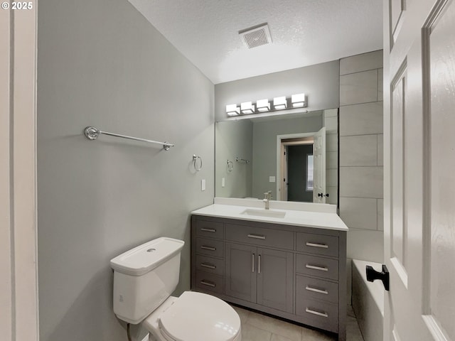 bathroom featuring a textured ceiling, tile patterned flooring, toilet, vanity, and visible vents