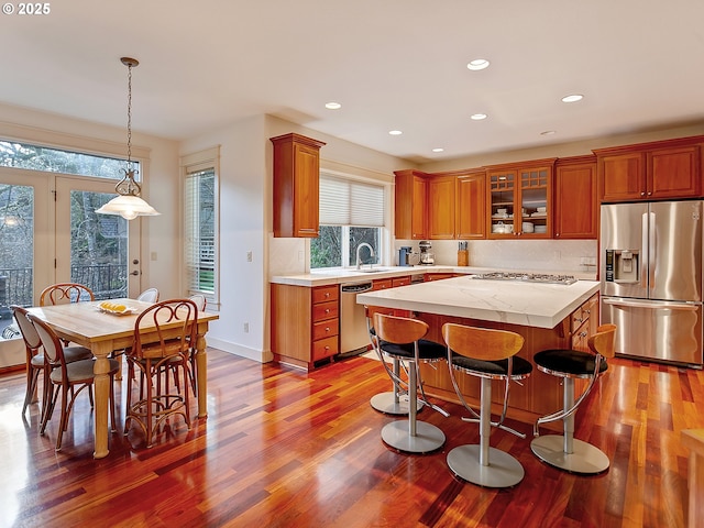 kitchen featuring tasteful backsplash, hardwood / wood-style floors, a kitchen island, and stainless steel appliances