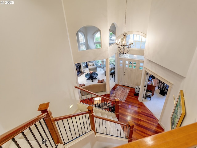 interior space featuring wood-type flooring, a high ceiling, and a chandelier