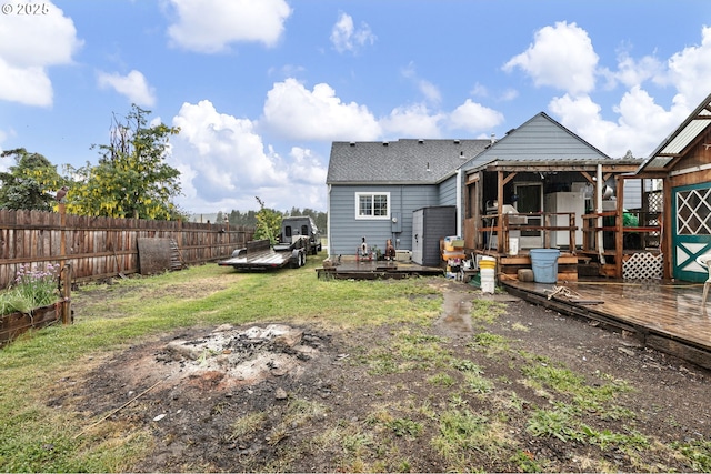 rear view of property with a wooden deck and a shingled roof
