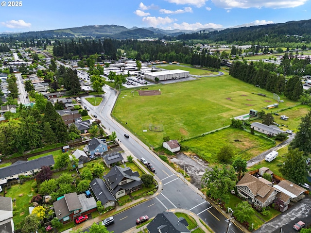 aerial view of property and surrounding area featuring mountains and nearby suburban area