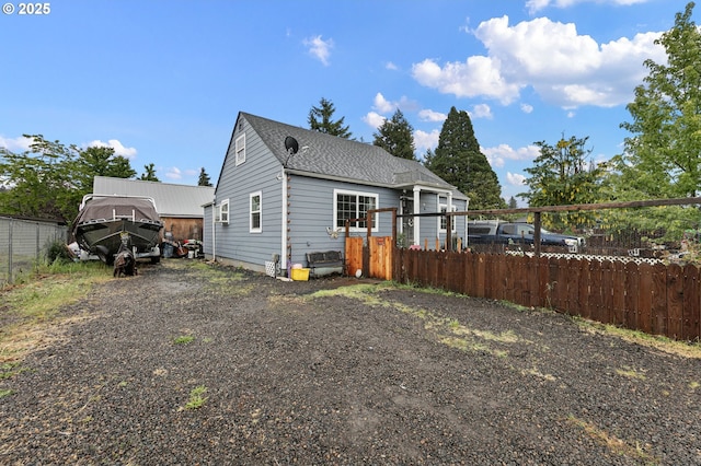 view of front of home featuring fence and roof with shingles
