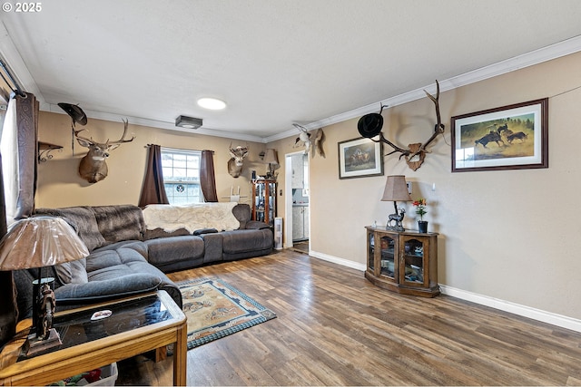 living area with crown molding, wood finished floors, and baseboards