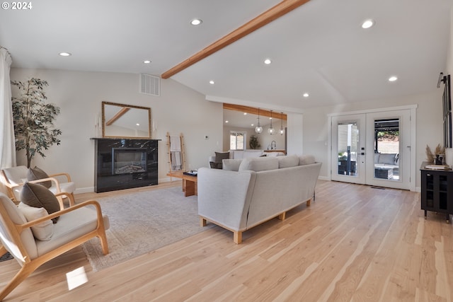 living room featuring plenty of natural light, light hardwood / wood-style flooring, french doors, and lofted ceiling with beams