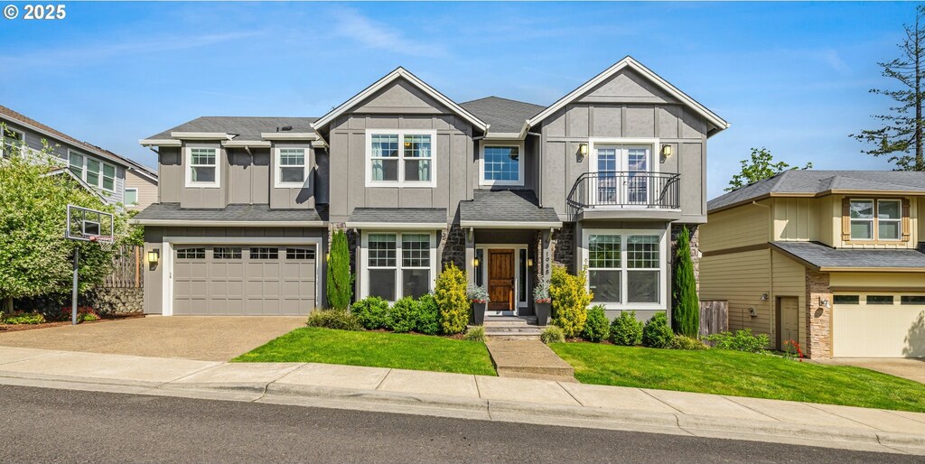 1988 NW 114th Ave, Portland, OR 97229 - view of front of home with a garage, board and batten siding, a front yard, concrete driveway, and a balcony