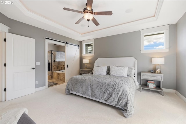 bedroom with baseboards, a barn door, carpet, and a tray ceiling