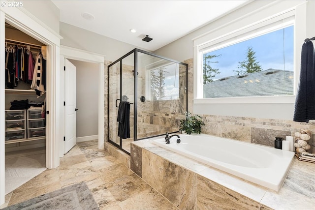 bathroom featuring a stall shower, a bath, and a spacious closet