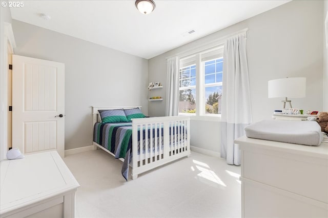 bedroom featuring baseboards, visible vents, and light carpet