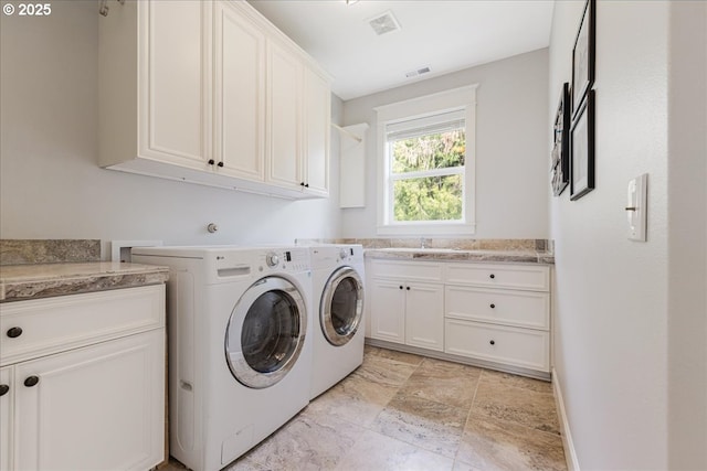 washroom featuring cabinet space, independent washer and dryer, visible vents, and a sink