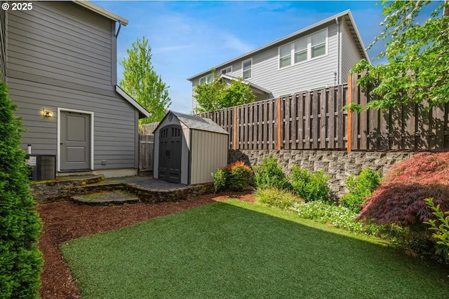 view of yard featuring a storage shed, fence, an outbuilding, and central air condition unit