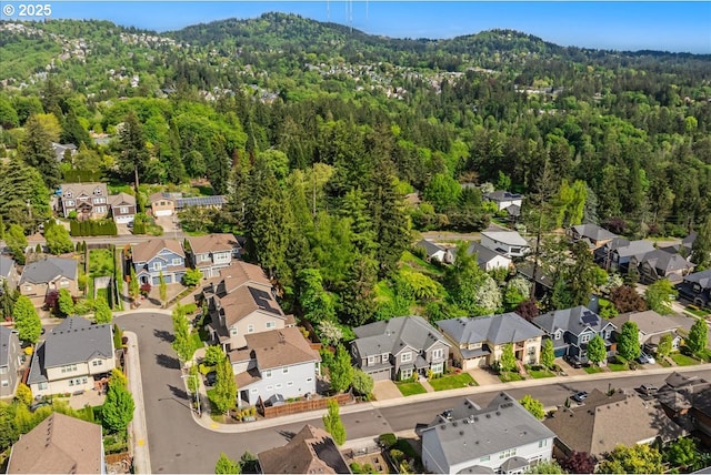 drone / aerial view featuring a residential view and a wooded view