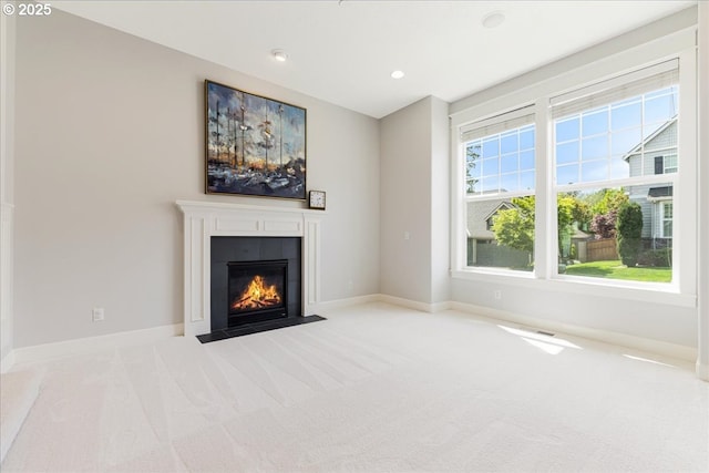 unfurnished living room with carpet flooring, recessed lighting, baseboards, and a tiled fireplace