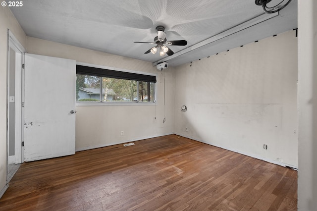 unfurnished room with visible vents, a ceiling fan, and wood finished floors