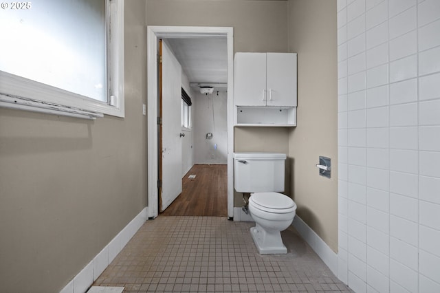 bathroom with tile patterned floors, baseboards, and toilet