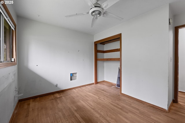 unfurnished bedroom with ceiling fan, a closet, baseboards, and wood finished floors