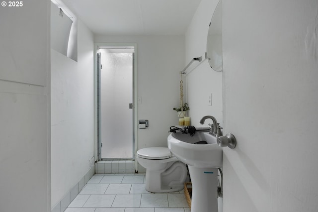 bathroom featuring tile patterned floors, toilet, and a stall shower