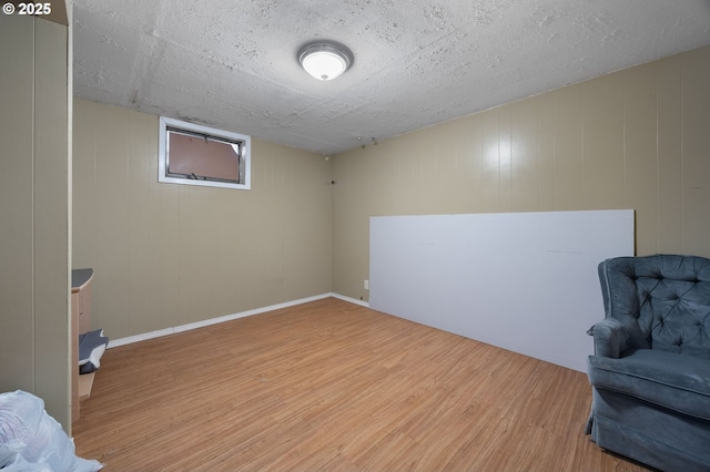 sitting room with wood finished floors, baseboards, and a textured ceiling